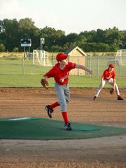 Cardinals pitcher Nate Bowman, left, throws the first pitch in a game July 13, between the Cardinals and Raptors of the 12-U Douglas County Amateur Baseball Assn. The Cardinals defeated the Raptors 22-4.