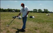 Ron Thomas uses a metal detector at the Wakarusa Music & Camping Festival site in hopes of picking up the spoils of the four-day series of concerts at Clinton Lake State Park.