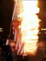 A protester burns an American flag to protest President Bush's second inauguration during a march in Portland, Ore., in this January 2005 file photo. The House on Wednesday approved a constitutional amendment that would give Congress the power to ban desecration of the American flag.