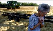 Clea Lee, 77, walks in a cut wheat field as her husband's crew prepares to move equipment to another field. This year marks the couple's 54th harvest.