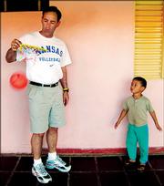 Kansas University volleyball coach Ray Bechard plays with a boy in Sao Paulo, Brazil. The Jayhawks traveled to Sao Paulo and Rio de Janeiro after the spring semester to bond, have fun and learn about Brazilian culture.
