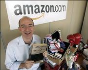 Amazon.com founder and CEO Jeff Bezos holds a copy of "Fluid Concepts and Creative Analogies" by Douglas Hofstadter - the first book sold online by Amazon.com - at the company's headquarters in Seattle. The company that sells a variety of items - including those on the table next to him - was launched on the Web 10 years ago.