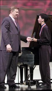 Scott McBride, of the International Institute, left, presents Charlie Albright, 16, of Centralia, Wash., the first-place trophy.