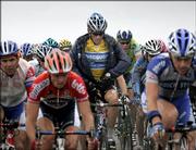 Overall leader Lance Armstrong, rear center, a six-time winner, zips his rain jacket as he pedals in the pack during the sixth stage of the Tour de France. Lorenzo Bernucci of Italy won the stage Thursday between Troyes and Nancy in eastern France.