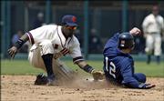 Kansas City shortstop Angel Berroa tags out Minnesota's Michael Ryan (12) as he tries to steal second base in the fifth inning. The Royals rallied, but lost to the Twins, 3-2 in 12 innings. Both squads wore Negro Leagues uniforms Sunday at Kansas City, Mo.