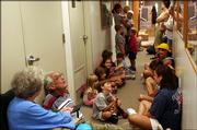 Caleb Carmichael, 6, center, plays games with his mother, Michelle, in the hallway of Gulf Breeze City Hall, as residents take shelter from Hurricane Dennis Sunday in Gulf Breeze, Fla.