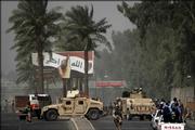 Under an Iraqi election billboard, U.S. troops, Iraqi police and Iraqi military arrive on the scene of a suicide bombing Sunday outside an Iraqi army recruiting center in Baghdad, Iraq. The billboard reads: "God Is Great. We swear by the blood in our veins and the ink on our finger that we will not be defeated."