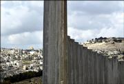 The golden shrine of the Dome of the Rock mosque in Jerusalem's Old city can be seen behind a wall being built in the village of Abu Dis on the outskirts of Jerusalem in this Dec. 29, 2003, file photo. Israel's separation barrier will cut off 55,000 Palestinian residents of Jerusalem from their city, Israel's Cabinet acknowledged Sunday, even as it decided to push ahead with the project over strident Palestinian objections and some U.S. misgivings.