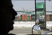 Truck driver David Zepeda, 39, is silhouetted June 28 as he drives his truck to the port of Long Beach, Calif. The twin ports of Los Angeles and Long Beach are girding themselves against the tide of goods from the Far East with a strategy to move nearly half of the landslide of cargo traffic at night and weekends.