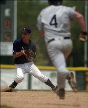 Lawrence Outlaws second baseman Matt Birtmer grabs the ball as Chanute's Blane Audiss runs toward the base. The Outlaws lost the first game of their doubleheader Sunday at Free State High, 6-0, but rebounded to win the nightcap, 12-9.