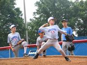Dylan French, 11, of Barrington, throws a pitch at the University of Kansas Super Skills baseball camp while other campers watch Saturday at Hoglund Ballpark.