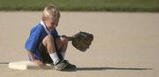 Cooper Rasmussen sits on second base as soon as he takes to the field, giggling during hist T-ball game Thurday at Broken Arrow Park.
