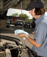 Dane Harris checks the oil for a customer at Westside 66 Thursday. The station offers full service, which can include checking the oil and tires, washing the windows as well as filling the car with fuel.