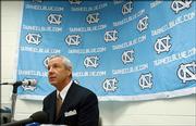 North Carolina men's basketball coach Roy Williams answers questions for reporters during the team's media day Oct. 16, 2003, at the Dean Smith Center in Chapel Hill, N.C. Williams said a communications breakdown lead to improper gifts being give to players while he was head basketball coach at Kansas University.