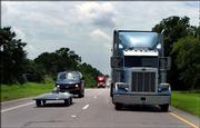 The Iowa State University solar car, left, drives at highway speed on U.S. Highway 82, Monday in Whitesboro, Okla., during the second day of the North American Solar Challenge. The Austin-to-Calgary race is the longest solar car race in the world.