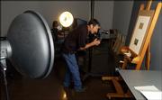 Robert Hickerson, photographer and database project manager at the Spencer Art Museum, frames up a shot as Nate Thames, Wichita, a digital imaging assistant and Kansas University student, looks on Tuesday at the museum. Hickerson and members of his staff are working to create a digital database of the collection at the museum.