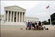 A group of demonstrators prays outside the Supreme Court on Tuesday. The group was praying that President Bush would pick a Supreme Court Justice who would make abortion illegal. Nominee John G. Roberts Jr. once helped write a brief that said Roe v. Wade should be overruled.