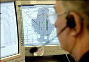 SuperShuttle dispatcher Terry Ogden keeps track of the the company's vehicles at Dallas-Fort Worth Airport. Green blocks on the computer screen represent a SuperShuttle vehicle.