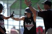 Phenix's Kalli McClure receives congratulations from a teammate and coach after scoring a run in the team's 12-2 rout of the Augusta Chill. The Phenix won Friday at the Youth Sports Inc. fields.