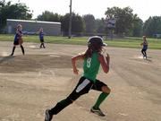 Mad Batters base runner Erica Lignell runs to first base during a Lawrence Girls Fast Pitch Assn. game against the Falcons on Thursday at Holcom. The Falcons won the game 15-5.