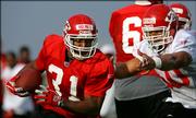 Kansas City running back Priest Holmes (31) turns the corner past linebacker Kawika Mitchell during the Chiefs' first day of training camp. Kansas City worked out Thursday in River Falls, Wis., in what could be Dick Vermeil's final year as Chiefs coach.