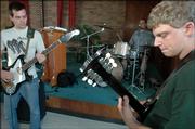 Musicians from left, bassist Jake Tinsley, drummer Nick Wells and guitarist Andy Litwiller perform a song while rehearsing for "Johnny Butts," an original rock musical by Wells and Andy Stowers.