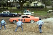 The General Lee races away from the police in a scene from "The Dukes of Hazzard." The promotional photo is one of many that obscures the Confederate battle flag painted on top of the stars&squot; Dodge Charger.