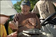 Henry Fitch holds a snake for 2-year-old Ethan Sharp to admire in this 2005 file photo. Fitch, a longtime professor and naturalist at Kansas University’s Natural History Reservation, died this week at age 99.