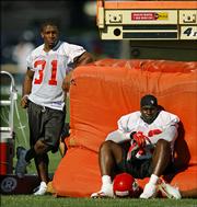 Kansas City running back Priest Holmes, left, takes off morning practice, as he has done throughout preseason training camp. Holmes watched Saturday's practice in River Falls, Wis., with fullback Tony Richardson.
