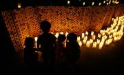 Children place candles outside the Atomic Bomb Dome at the 60th anniversary of the atomic bombing Saturday in Hiroshima, western Japan. At 8:15 a.m., the moment of the blast, the city's trolleys stopped as more than 55,000 people observed a moment of silence for the victims of the bomb.