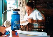 KU law school graduate Amy Kuhn, of Coldwater, studies for the bar exam near the front window of the Nova Cyber Cafe, 745 N.H. Downtown coffee shops are popular hangouts for Lawrence students who are cramming for an exam or just out to socialize.