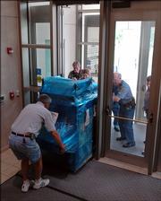 Bill Bell, County building maintenance director, foreground, and Douglas County sheriff's deputies deliver a new security screening machine to the Douglas County Judicial and Law Enforcement Center, 111 E. 11th St. The machine, which is similar to an airport conveyor belt scanner for bags, purses and other small items, will be used along with a walk-through scanner for security purposes at the entrance to the center.