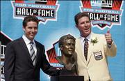 Former Miami Dolphins quarterback Dan Marino poses with his bust after his enshrinement in the Pro Football Hall of Fame. Marino was honored Sunday in Canton, Ohio.