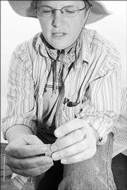 Janice McLean, a Kansas University master's student, examines a stone flake found at an archaeological dig site near Kanorado. The flake, possibly a piece of a tool, is typical of the finds at the site, which may be one of the earliest human sites found in the Great Plains.