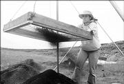 Kim Kilmartin, a sophomore at Baker University, sifts through dirt collected at an archaeological dig site near Kanorado, hoping to find flakes of bone or rock that might help date the site. Researchers think the site could be one of the oldest signs of humans found in the Great Plains.