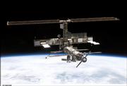 This image shows the International Space Station backdropped by the blackness of space and Earth's horizon, photographed Saturday by a crewmember onboard the space shuttle Discovery.