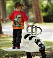 Savannah Grace Beckerman, of Kansas City, Mo., takes a space walk of sorts Monday on a toy space shuttle located in a city park in Eudora. The real space shuttle, Discovery, is expected to return to the Kennedy Space Center today after weather delayed Monday's attempt.