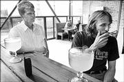 Kansas University student Andy Harrington, an Olathe senior, left, and recent grad Matt Gronniger, of Lawrence, smoke outside ot the patio at Louise's Bar Downtown, 1009 Mass. St.