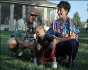 Jeff Krall tries to keep control of the family's energetic dog, Boots, while his wife, Natalie Griego, holds their 1-year-old son, Logan. Griego, a physician, will leave for training for a second tour in Iraq on Friday. It has become increasingly common for service personnel, including doctors, to serve multiple tours. This time, Griego will be away from her family for more than three months.