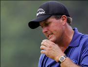 Phil Mickelson reacts to missing a par putt on the ninth green of the final round of the PGA Championship. Mickelson was leading at 4-under par through 13 holes of Sunday's round at Baltusrol Golf Club in Springfield, N.J. Bad weather postponed the conclusion of the round until today.