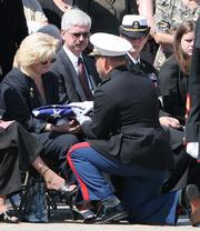 Kathy Dyer, mother of Marine Lance Cpl. Christopher Dyer, is presented the U.S. flag at the Tri-County Baptist Church during a memorial celebration in West Chester, Ohio. Dyer was killed in action in Western Iraq on Aug. 3. Christopher's father, John Dyer, is at center.