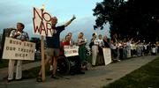 Anti-war protesters wave at passing motorists at a candlelight vigil in support of Cindy Sheehan in Kansas City, Mo. Vigils were held across the country on Wednesday night.