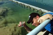 David Brewer, a water quality technician, gathers a water sample from one of the city's water treatment plants.