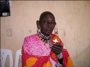 A Kenyan woman dressed in traditional clothing displays a glow-in-the-dark plastic cross given to her by Dr. Stephen Segebrecht of Lawrence during a recent mission trip there. Employees of the Lawrence Surgery Center, 1112 W. Sixth St., donated 300 crosses to send with Segebrecht on the trip.