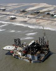 An oil platform, that was ripped Tuesday from its mooring in the Gulf of Mexico, rests by the shore in Dauphin Island, Ala., after hurricane Katrina passed through the area. The potential damage to oil platforms, refineries and pipelines that remain closed along the Gulf Coast drove energy prices to new highs Tuesday, with crude futures briefly topping $70 a barrel and wholesale gasoline costs surging to levels that could lead to $3 a gallon at the pump in some markets.