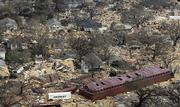 A barge, as well as shipping containers and loose lumber cover a neighborhood in an aerial view of damage Wednesday from Hurricane Katrina in Gulfport, Miss.