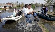 Volunteer Mickey Monceaux carries David Johnson, who could not walk, to safety after he used his boat to rescue Johnson and other residents from a flooded neighborhood Wednesday on the east side of New Orleans. Hurricane Katrina left much of the city under water. Officials called for a mandatory evacuation of the city, but many residents remained and had to be rescued.