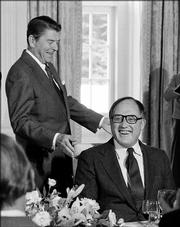 Supreme Court Justice William Rehnquist, right, celebrates his 58th birthday as President Ronald Reagan looks on, during a luncheon in the state dining room of the White House, in this Oct. 2, 1982 file photo.
