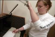 Juliann Howat, a Kansas University freshman, retrieves a document from a Braille printer. Howat works at KU to help translate music into Braille.