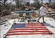 Retired Army Gen. Randolph Bourgeuis walks around an American flag he recovered Monday from his home which was destroyed by Hurricane Katrina in Bay St Louis, Miss.